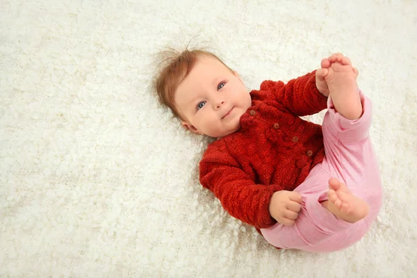 Cute baby in red clothes on blanket — Stock Photo, Image