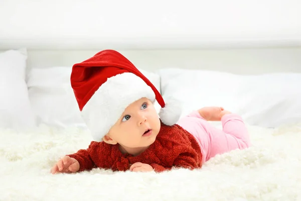 Schattige baby in KERSTMUTS op bed — Stockfoto