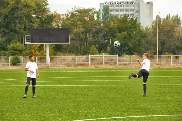 Chłopcy gry piłki nożnej na stadionie — Zdjęcie stockowe