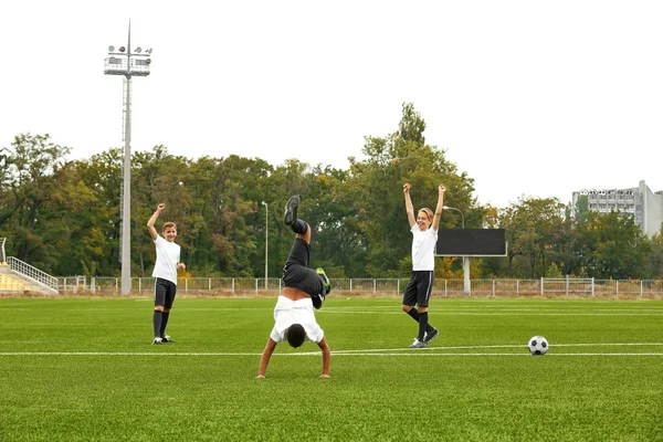 Pojkar spelar fotboll på stadion — Stockfoto
