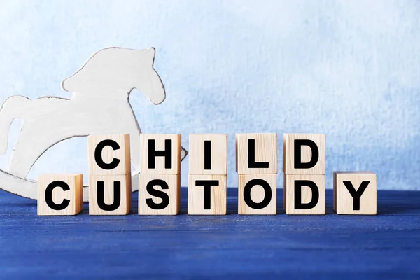 Кубики з текстом CHILD CUSTODY та іграшка на світлому фоні — стокове фото