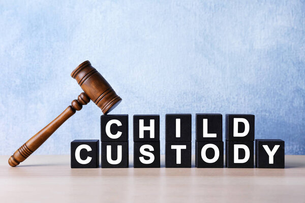 Court gavel and cubes with text CHILD CUSTODY on light background