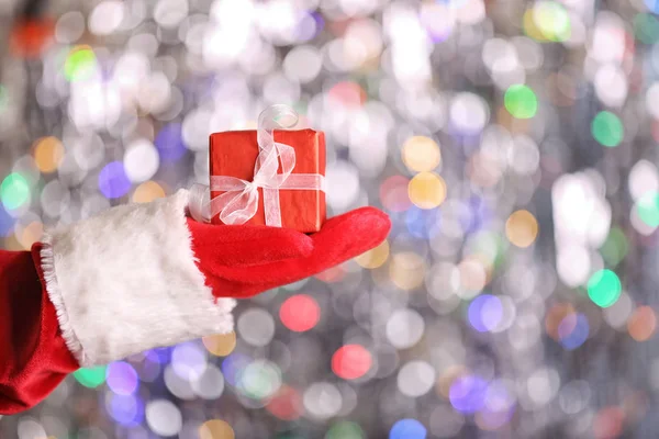 Santa Claus handen håller presentförpackning — Stockfoto