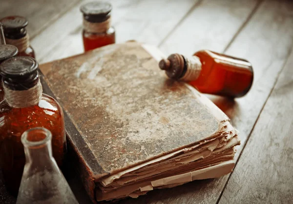 Стара книга зі скляними пляшками — стокове фото