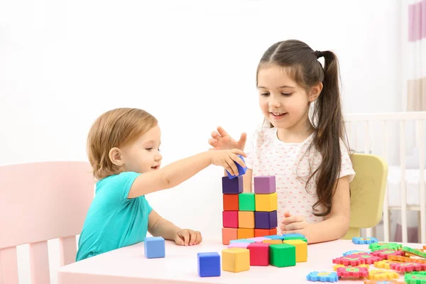 Мила дівчина грає з маленькою сестрою вдома — стокове фото