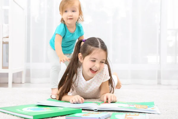 可爱的小女孩与小妹妹在家看书 — 图库照片
