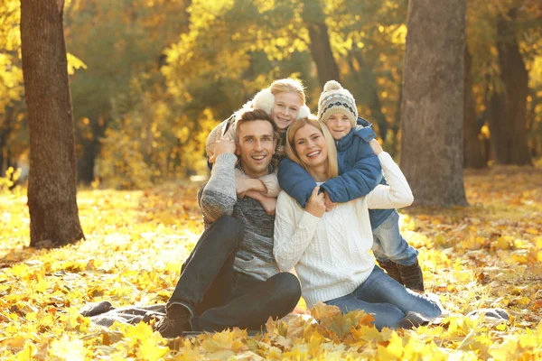 Lycklig familj vilar i vacker höst park — Stockfoto