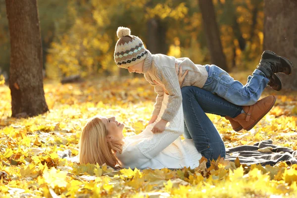Moeder en zoon spelen in mooie herfst park — Stockfoto