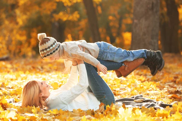 Mutter und Sohn spielen im schönen Herbstpark — Stockfoto