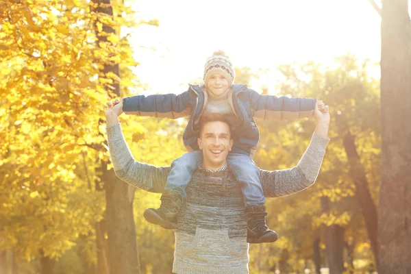 Vader en zoon spelen in mooie herfst park — Stockfoto