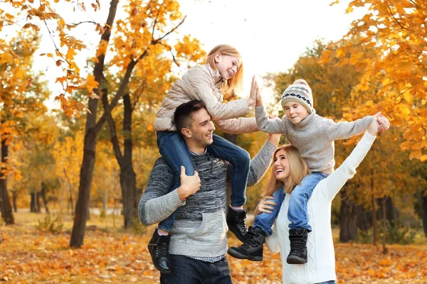 Família feliz jogando no belo parque de outono — Fotografia de Stock