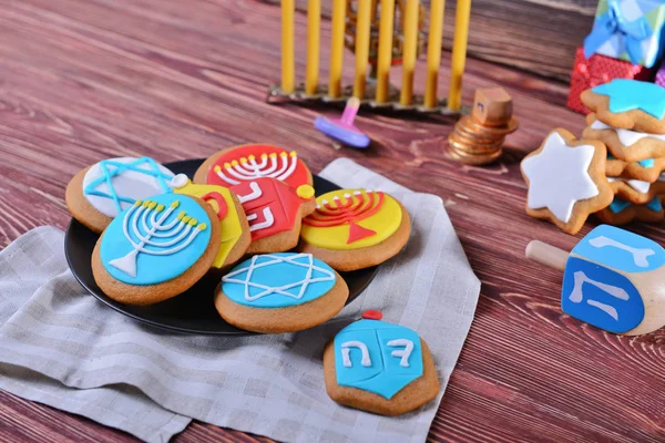 Piatto con gustosi biscotti smaltati per Hanukkah su tavolo di legno — Foto Stock