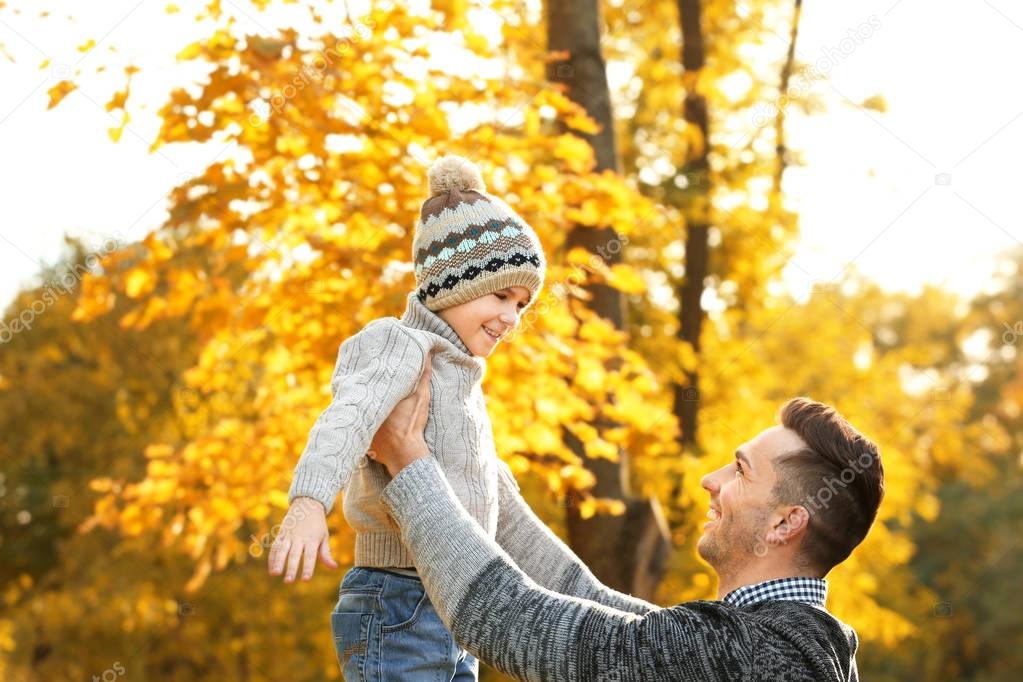 Father and son playing in beautiful autumn park