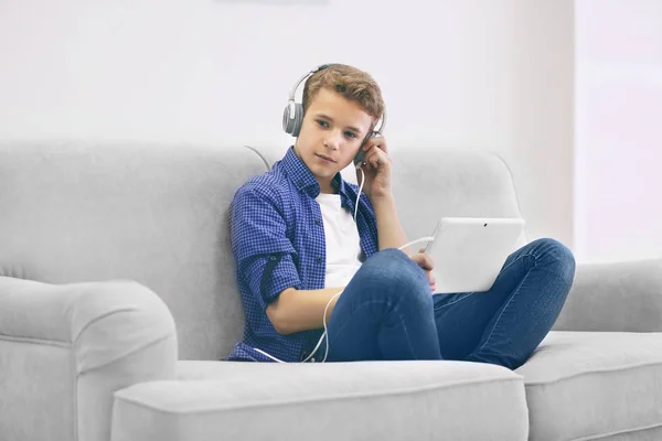 Мальчик слушает музыку на диване — стоковое фото