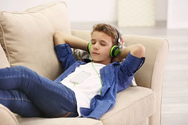 Niño escuchando música en el sofá — Foto de Stock