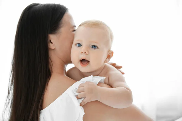 Mother holding little baby on light background — Stock Photo, Image