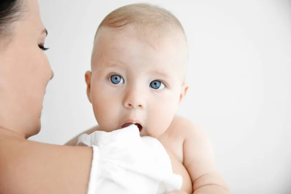 Mãe segurando pequeno bebê dentro de casa — Fotografia de Stock