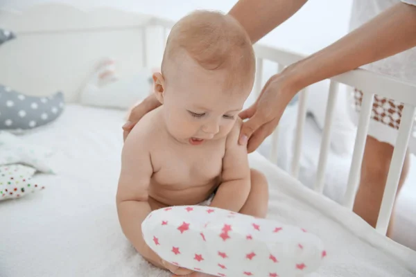 Matka ręce, trzymając małe dziecko w pomieszczeniu niemowlęcym — Zdjęcie stockowe