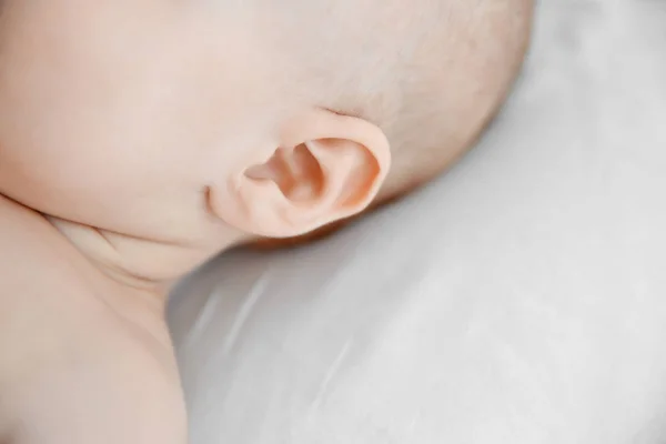 赤ちゃんの白いベッド、クローズ アップの耳 — ストック写真
