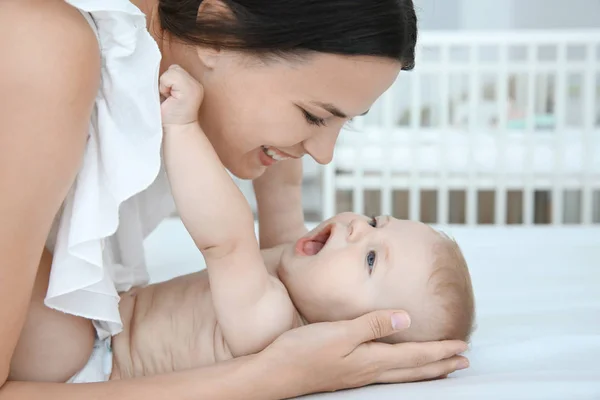 Mamma tittar på hennes baby inomhus — Stockfoto