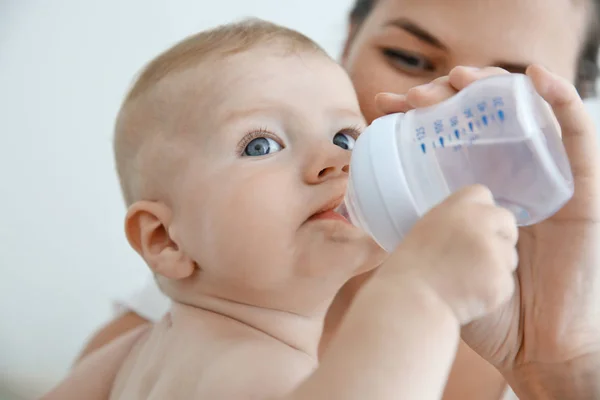 放弃从瓶子里，特写喝水婴儿的母亲 — 图库照片