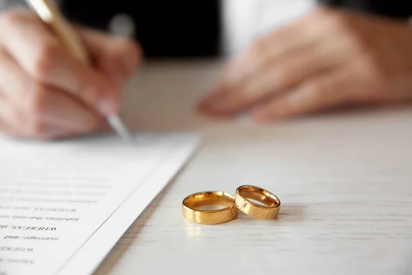 Anéis de casamento dourados na mesa no escritório do notário, close-up — Fotografia de Stock