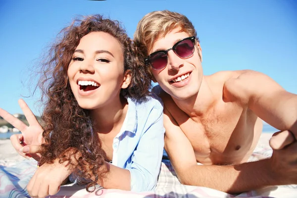 Счастливая пара делает селфи на пляже — стоковое фото