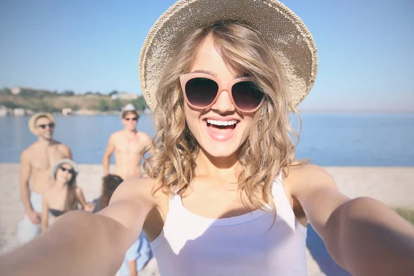 美丽的女孩，在考虑自拍照在海滩上的太阳镜 — 图库照片