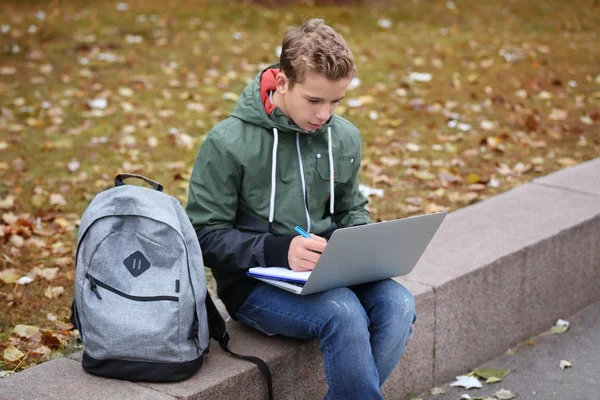 Parapet laptop ve Not Defteri ile sonbahar günü içinde oturan genç — Stok fotoğraf