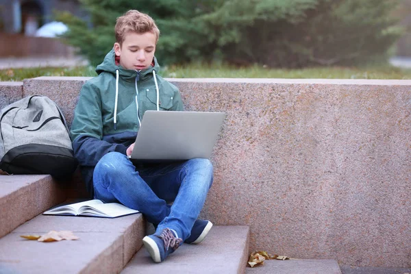 Tiener met laptop zitting — Stockfoto