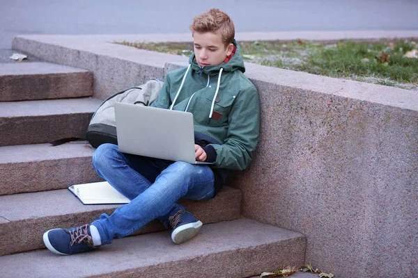 Tiener met laptop zitting — Stockfoto