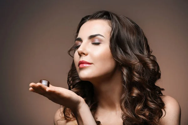 Hermosa chica con chocolate sobre fondo marrón —  Fotos de Stock