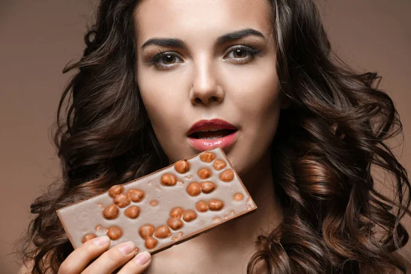 Beautiful girl with chocolate on brown background — Stock Photo, Image