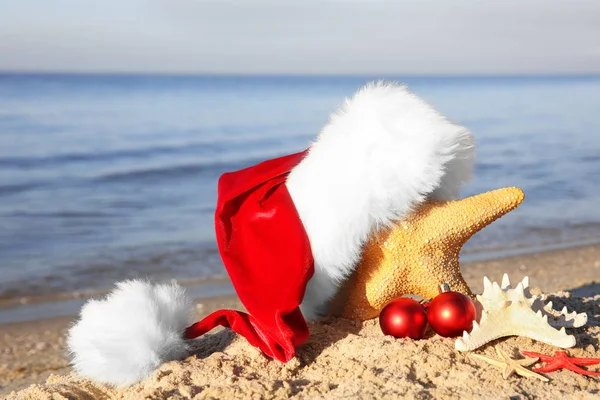 Santa hat with sea stars on beach — Stock Photo, Image