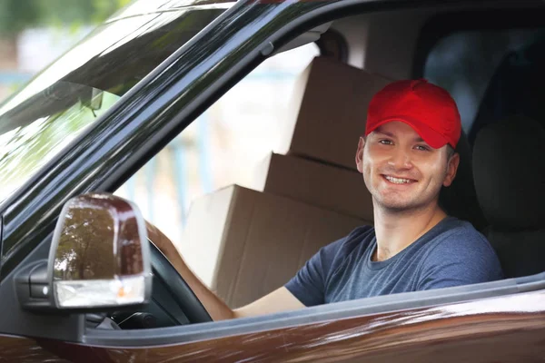 Junge männliche Zusteller mit Kisten im Auto — Stockfoto