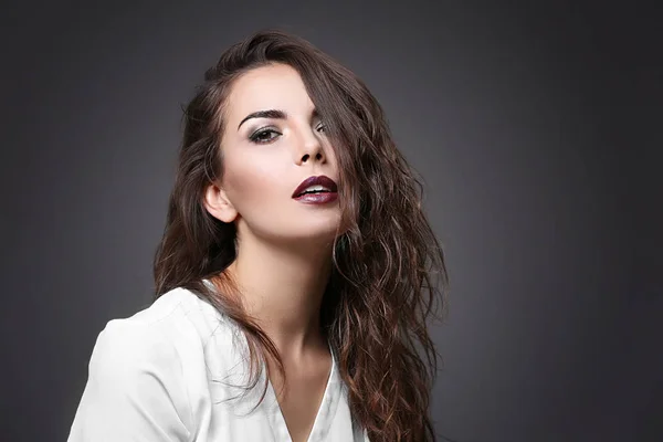 Portrait de belle jeune femme modèle avec un maquillage lumineux sur fond sombre — Photo