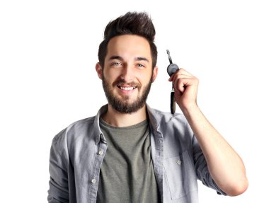 Araba anahtarı, gri arka plan üzerinde tutan genç adam portresi