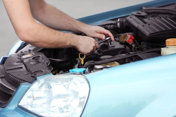 Mekaniker händer reparera bilen i öppen huv — Stockfoto