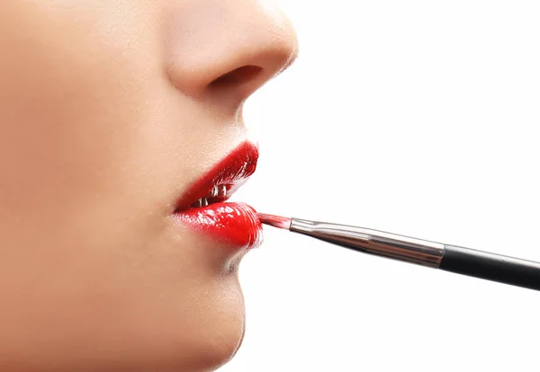 Beautiful girl applying cosmetics on white background — Stock Photo, Image