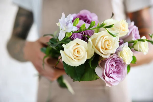 Manliga florist holding vacker bukett på blomsteraffär — Stockfoto