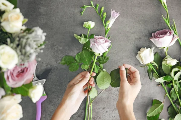 Женщина-флорист делает красивый букет в цветочном магазине — стоковое фото