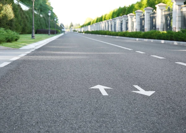Pijl tekent op asfaltweg tonen van de richting van de beweging — Stockfoto