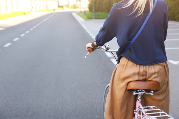 Młoda kobieta jazdy na rowerze wzdłuż drogi, zbliżenie — Zdjęcie stockowe