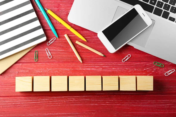 Portatile, copybook e cubi di legno su sfondo a colori — Foto Stock