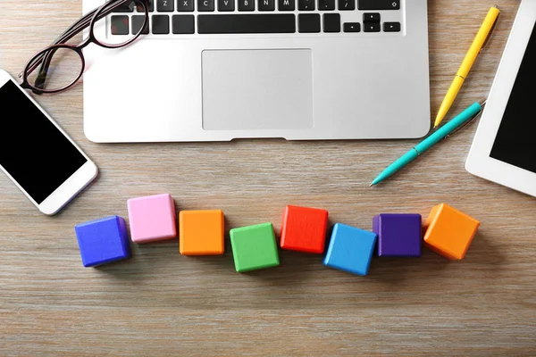 Portátil y cubos de madera sobre fondo de color — Foto de Stock