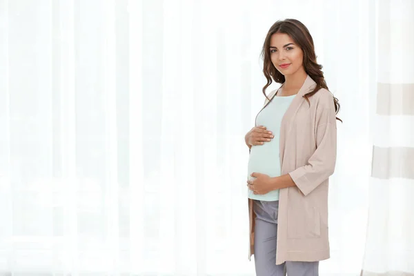 Zwangere vrouw stond in de buurt van venster — Stockfoto