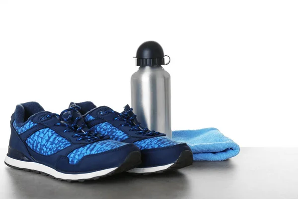 Sportschuhe, Handtuch und Flasche auf dem Tisch — Stockfoto