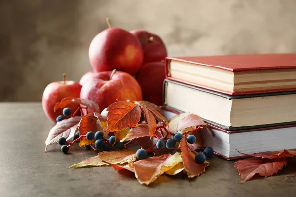 Schöne Herbstkomposition mit Bücherstapel auf grauem Hintergrund — Stockfoto