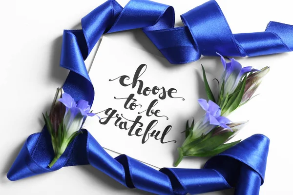 Επιγραφή «Επιλέγουν να είναι ευγνώμων» γραμμένο σε χαρτί με άνθη και κορδέλα σε άσπρο φόντο — Φωτογραφία Αρχείου