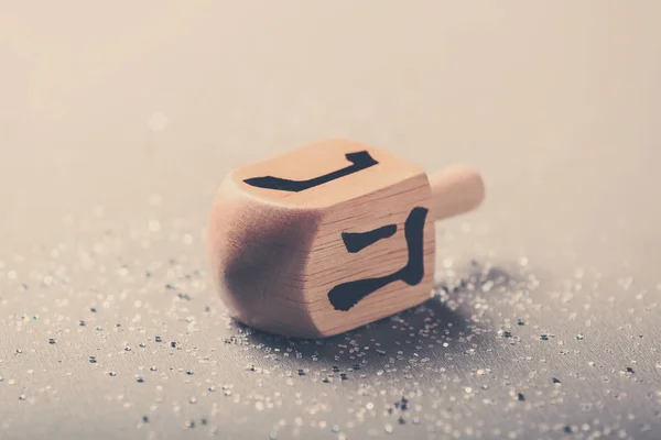 Wooden dreidel for Hanukkah on light background — Stock Photo, Image